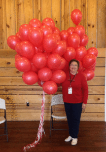 Linda Sutton Holds 100 Red Balloons